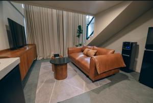 a living room with a leather couch and a table at Wolu Designer Loft - Private Pool & Tropical Garden, Canggu in Tumbak Bayuh