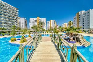 a bridge over a pool in a city with tall buildings at Luxury 2 Bedroom Apartment in Caesar Resort in Iskele