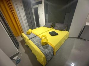 a bedroom with a yellow bed with a yellow blanket at Bluxury in Kumanovo