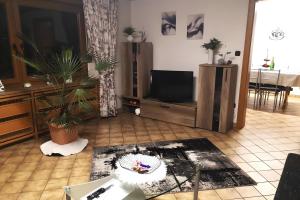 a living room with a flat screen tv and a table at Zur kleinen Auszeit in Issigau