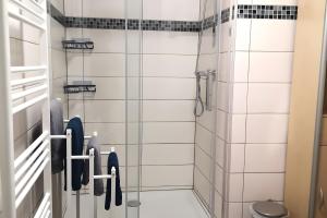 a bathroom with white tiled walls and a shower at Zur kleinen Auszeit in Issigau +19 photos