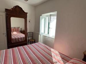 a bedroom with a bed and a mirror at Casa nel borgo - A Rigadèa in Groppo