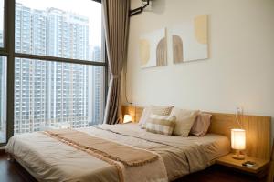 a bedroom with a bed and a large window at A Quiet Stay - Service Apartment, Vinhome Ocean Park, Ha Noi in Gia Lâm Pho