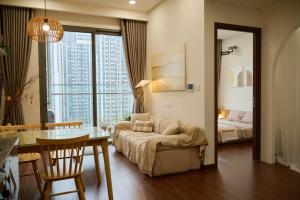 a living room with a couch and a table and a bedroom at A Quiet Stay - Service Apartment, Vinhome Ocean Park, Ha Noi in Gia Lâm Pho