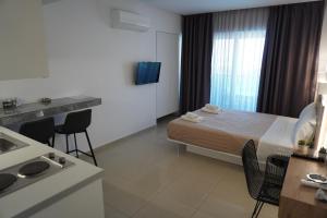 a small hotel room with a bed and a kitchen at Aestas Apartments in Agia Marina Nea Kydonias