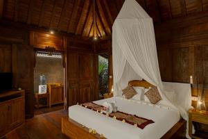 a bedroom with a bed with a canopy at Bumbung Sari Villa in Ubud +163 photos