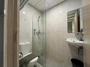 a bathroom with a shower and a toilet and a sink at Front One Hotel Gresik in Panggang +9 photos
