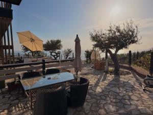 a patio with a table and an umbrella at Rahoni Park & Apartments in Dhërmi