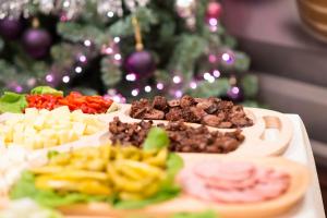 a table topped with different types of food in front of a christmas tree at Pridvorul Haiducilor in Slănic-Moldova