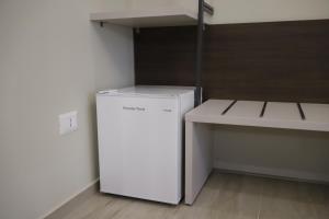 a white refrigerator in a room with a table at Seõra Luxury Rooms in Porto Empedocle +76 photos