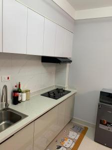 a white kitchen with a sink and a stove at EM Homes Modern 1-Bedroom Apartment with Pool 15 Minutes from JKIA Airport in Marimbeti