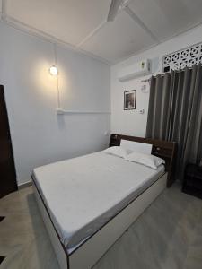 a bedroom with a large bed in a room at Camellia The Bungalow in Dibrugarh +7 photos