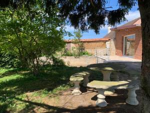 a stone table and bench in a yard at La CléryNette in Les Andelys