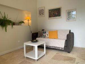 a living room with a couch and a table at La CléryNette in Les Andelys