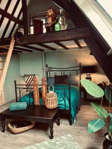 a bedroom with a green bed and a table at Slapen bij Café de Concurrent in Vlissingen