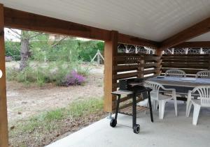 a table and chairs on a porch with a piano at Appartement 4p Sanguinet-Doum Doum in Sanguinet