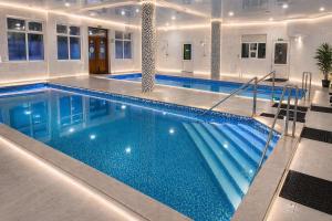 a large swimming pool with blue water in a building at HotelVizit in Solotvyno