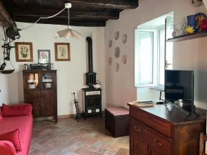 a living room with a red couch and a stove at Casa nel borgo - A Rigadèa in Groppo