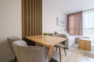 a living room with a table and chairs and a couch at River View 1-Bedroom Apartment in Plovdiv