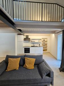a living room with a couch with yellow pillows at La Cereria MARIA in Chiavenna