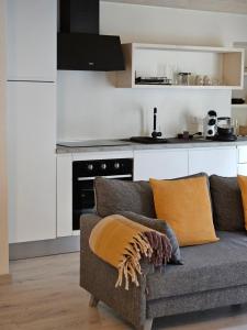 a living room with a couch and a kitchen at La Cereria MARIA in Chiavenna