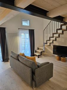 a living room with a couch and a staircase at La Cereria MARIA in Chiavenna
