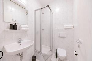ein weißes Badezimmer mit Waschbecken und Dusche in der Unterkunft Hillerts Hotel in Rheda-Wiedenbrück + 17 Fotos