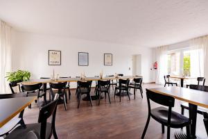ein großes Esszimmer mit Tischen und Stühlen in der Unterkunft Hillerts Hotel in Rheda-Wiedenbrück