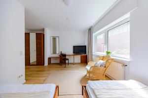 ein Zimmer mit zwei Betten und einem Schreibtisch mit Fernseher in der Unterkunft Hillerts Hotel in Rheda-Wiedenbrück
