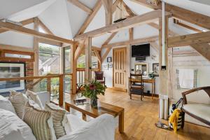 a living room with white furniture and wooden beams at Barberry Brook - Swimming pool acces in Dittisham