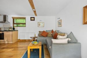 a living room with a couch and a table at Barberry Brook - Swimming pool acces in Dittisham