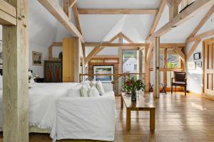 a large bedroom with a white bed and a table at Barberry Brook - Swimming pool acces in Dittisham +34 photos