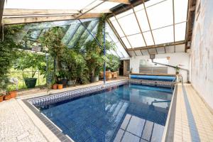 a swimming pool in a building with a glass ceiling at Barberry Brook - Swimming pool acces in Dittisham