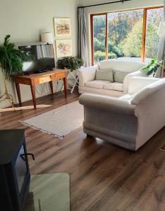 a living room with a couch and a tv at Valley View the home with a view in Nottingham Road