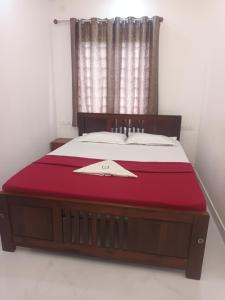 a bedroom with a large bed with a red blanket at S P Nettoor in Cochin