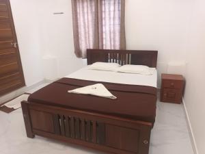 a bedroom with a large bed with a wooden foot board at S P Nettoor in Cochin