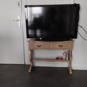 a television on a wooden stand in a room at Möblierte Zimmer in privater Wohnung in Köln Heimersdorf in Cologne