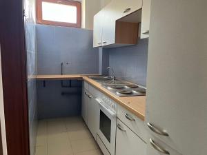 a small kitchen with a stove and a sink at Napsugár Apartman in Szaknyér