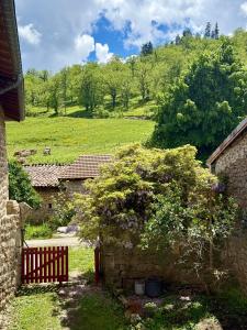 a stone building with a fence and a tree at La Grange de Bosc -Ardèche verte - Proche train de Lamastre in Saint-Prix