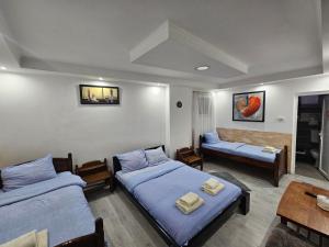 a bedroom with two beds and a couch and a table at Prenociste Simke 2 in Subotica