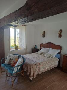 a bedroom with a bed and a chair with a baby in it at Chambre d'hôtes Chez Sarah in Saint-Bon
