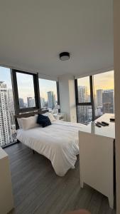 a bedroom with a large white bed with large windows at The Downtown Luxury Collection in Miami +119 photos