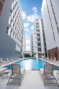 a swimming pool with lounge chairs and buildings at Sama Hotels in Dakar