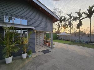 a house with a porch with plants in front of it at Camellia The Bungalow in Dibrugarh