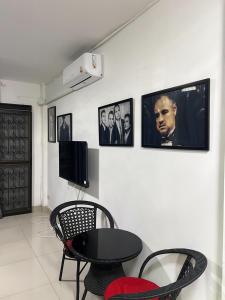 a room with a table and chairs and pictures on the wall at Escobar guest house jomtien in Ban Nong Tabaek