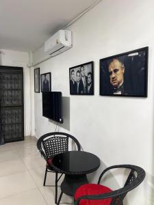 a room with a table and chairs and pictures on the wall at Escobar guest house jomtien in Ban Nong Tabaek