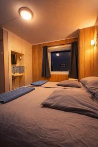 two beds in a room with a window at Homestay Hammerfest - Central - Lakeview in Hammerfest