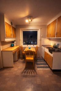 a small kitchen with a table and a table and chairs at Homestay Hammerfest - Central - Lakeview in Hammerfest +10 photos