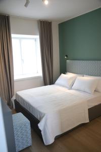 a bedroom with a large white bed with a window at TAU Rooms Srl in Tricesimo
