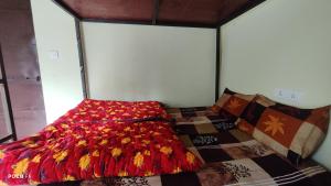 a bedroom with a bed with a quilt on it at The Kedar Heights in Gupta Kāshi +15 photos